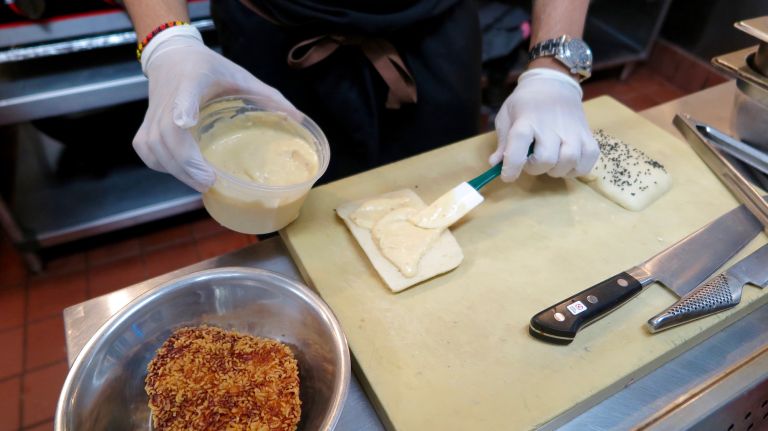 Barrera spreads the aioli with shallots on the bun. 