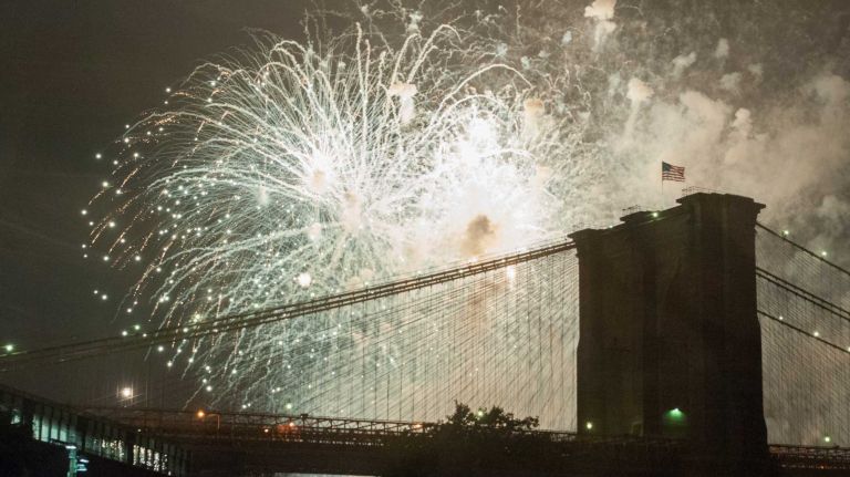 People watch the Macy's 4th of July Fireworks from Brooklyn Bridge Park on July 4, 2016.