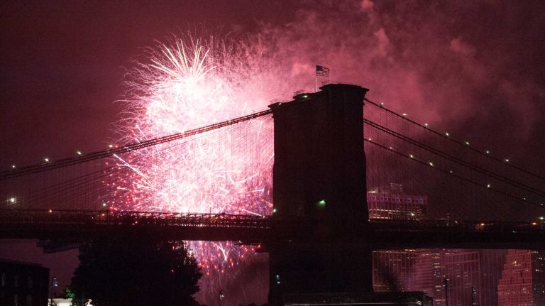 People watch the Macy's 4th of July Fireworks from Brooklyn Bridge Park on July 4, 2016.