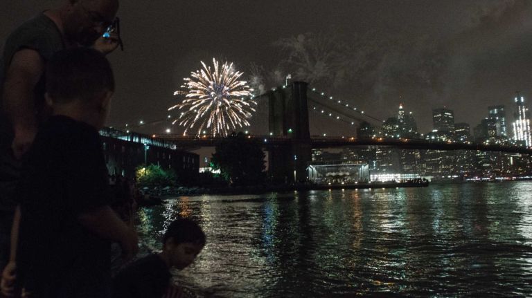 People watch the Macy's 4th of July Fireworks from Brooklyn Bridge Park on July 4, 2016.