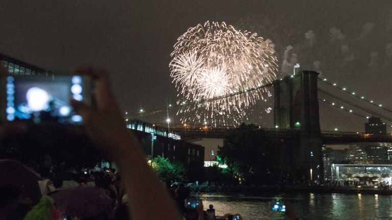 People watch the Macy's 4th of July Fireworks from Brooklyn Bridge Park on July 4, 2016.