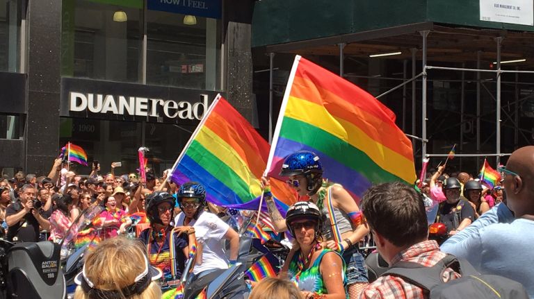 NYC Pride March participants ride bikes decorated with rainbow flags during the annual celebration on Fifth Avenue in Manhattan on June 25, 2017.