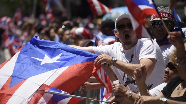 Spectators lining Fifth Avenue celebrate during the 59th annual Puerto Rican Day Parade in Manhattan on Sunday, June 12, 2016. 