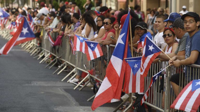 Spectators lining Fifth Avenue wait for the start of the Puerto Rican Day Parade in Manhattan on Sunday, June 12, 2016.