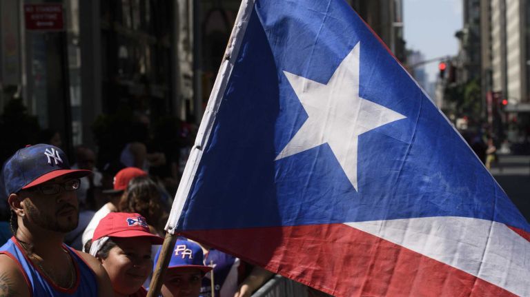 Spectators line Fifth Avenue as they wait for the start of the Puerto Rican Day Parade in Manhattan on Sunday, June 12, 2016.