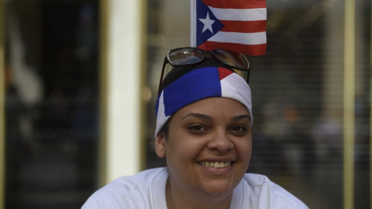 Diane Sanchez, who lives in Sunset Park, Brooklyn, waits for the start of the Puerto Rican Day Parade in Manhattan on Sunday, June 12, 2016.