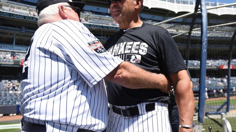 Former New York Yankees manager Stump Merrill and Reggie Jackson embrace during the 70th annual Old-Timers' Day at Yankee Stadium on Sunday, June 12, 2016.