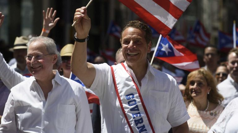 New York State Governor Andrew Cuomo, center, marches in the 59th Annual Puerto Rican Day Parade in Manhattan on Sunday, June 12, 2016. The National Puerto Rican Day Parade's theme Un Pueblo, Muchas Voces (One Nation, Many Voices) celebrates the creativity and diversity of thought in Puerto Rico and across the diaspora.