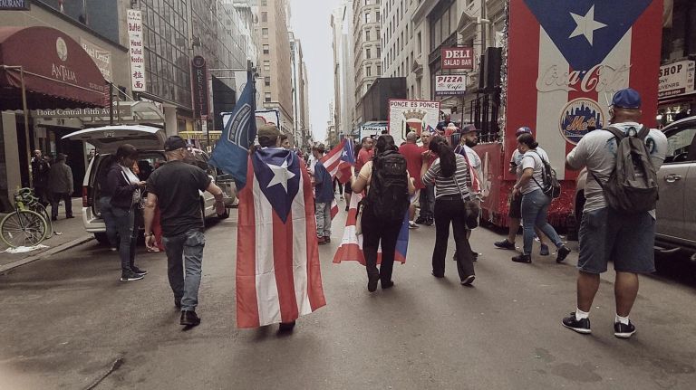 Paradegoers walk the route before the 61st annual National Puerto Rican Day Parade.