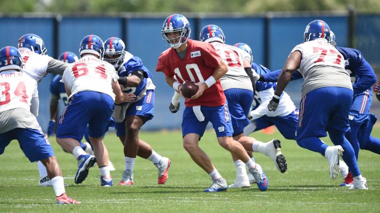 New York Giants quarterback Eli Manning and teammates run a drill during the Giants Organized Team Activities at Quest Diagnostics Training Center on Wednesday, June 1, 2016.