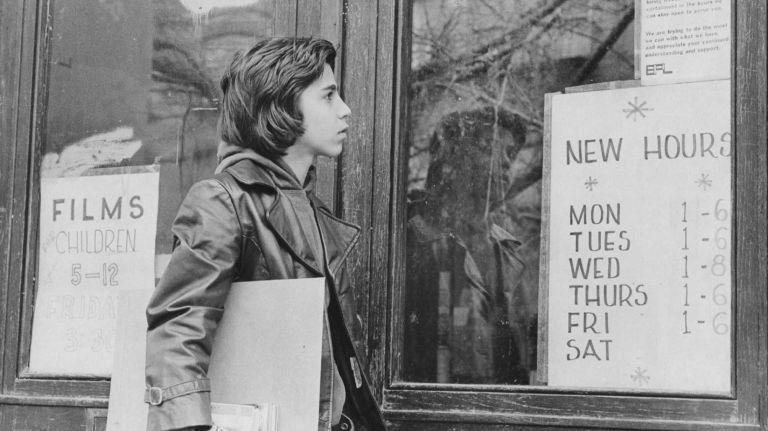 David Mulia, of Park Slope, reads the sign on the door of the Brooklyn Public Library branch on 6th Avenue on April 3, 1976. Due to cut-backs the library had new hours and was closed on Saturdays.