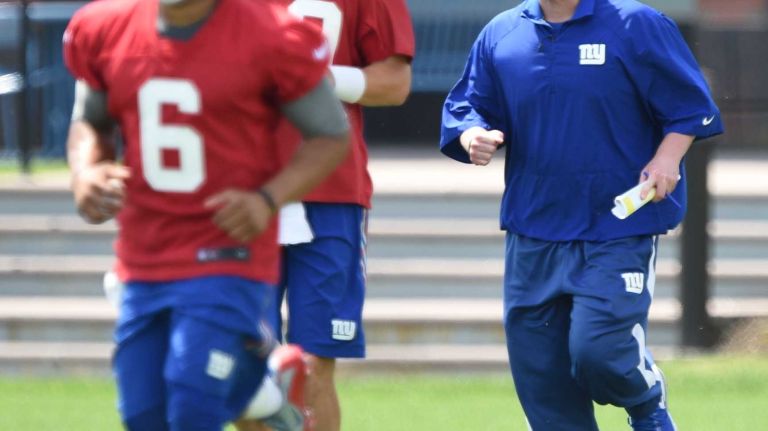 New York Giants head coach Ben McAdoo runs behind Giants quarterbacks during the Giants Organized Team Activities at Quest Diagnostics Training Center on Wednesday, June 1, 2016.