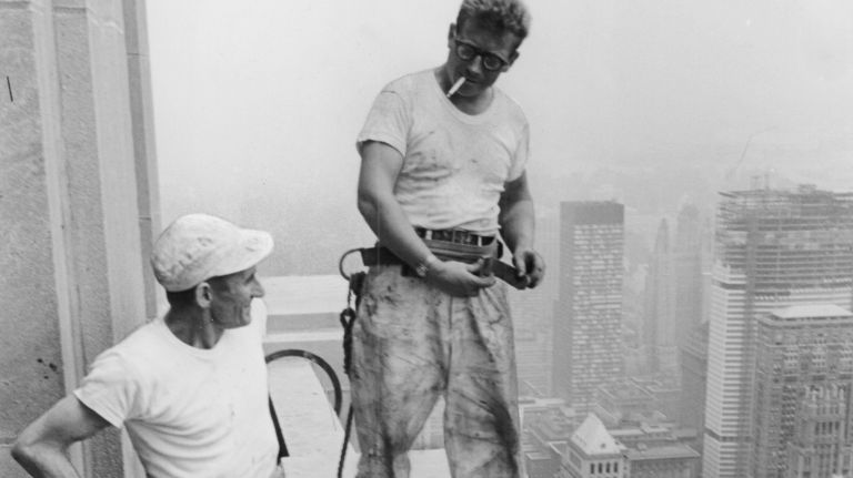 Eggert Johannsen, of Brooklyn, and Harry Dane, of the Bronx, fasten their safety belts while working outside of the 85th floor of the Empire State Building in July 1962. The pair were part of a crew working on a renovation of the skyscraper's exterior.