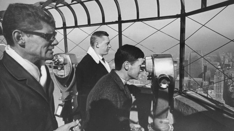 Tourists from Brazil and Germany take in the view from the observation deck on the 85th floor of the Empire State Building on Jan. 16, 1964.
