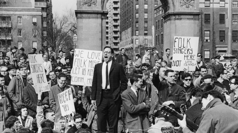 Folklorist Israel Young leads a protest against a ban on folk music in Washington Square Park on April 9, 1961. Protest signs read 