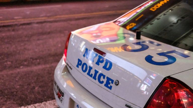  Parked NYPD police vehicle seen at a roadside during nighttime.