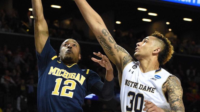 NCAA Tournament: Notre Dame vs. Michigan 20 Michigan Wolverines guard Muhammad-Ali Abdur-Rahkman puts up a shot past Notre Dame Fighting Irish forward Zach Auguste during the first round of an East Regional men's basketball game in the NCAA Tournament at Barclays Center on Friday, March 18, 2016.