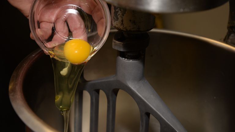 As the milk and sugar are mixing, add 2 large eggs. 