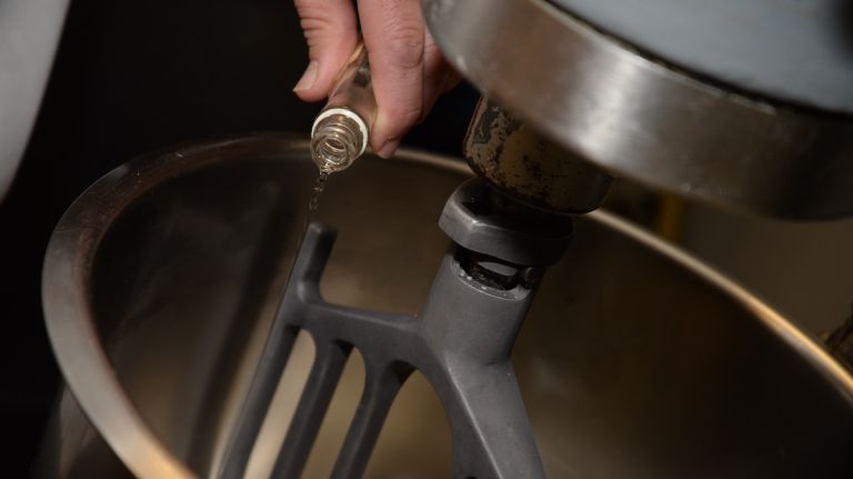 Chef Scognamillo eyeballs how much anise extract to add to the mixer. Rule of thumb: If using extract instead of seeds, drizzle a thin stream into the bowl for about 2 seconds.