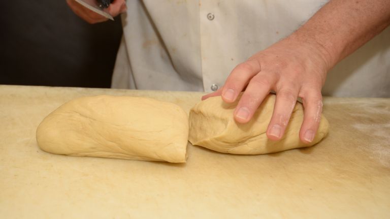 Take the dough from the bowl, put it on a floured surface and cut into two (or three) pieces.