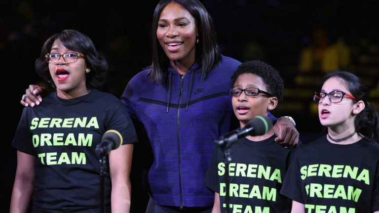 Serena Williams looks on with members of a children's choir from center court during the 9th annual BNP Paribas Showdown at Madison Square Garden on Tuesday, March 8, 2016.