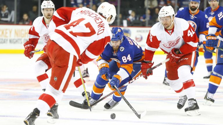 Mikhail Grabovski #84 of the New York Islanders tries to control the puck in the first period against Alexei Marchenko #47 and Luke Glendening #41 of the Detroit Red Wings at Barclays Center on Monday, Feb. 15, 2016 in Brooklyn, New York.