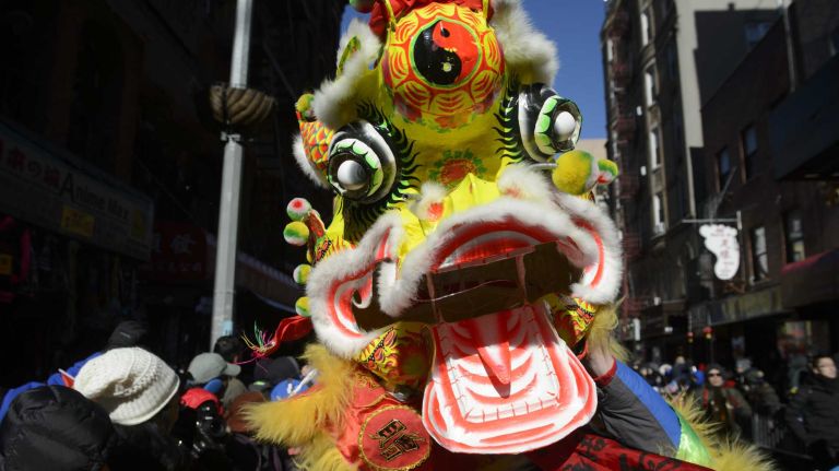 A participant wears a dragon head at the Lunar New Year Parade welcoming the Year of the Monkey in Manhattan's Chinatown on Sunday, Feb. 14, 2016. The monkey is the ninth of the 12-year cycle of animals that appear in the Chinese zodiac, related to the Chinese calendar.