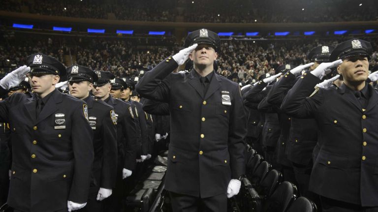 NYPD officer graduations, Dec. 29, 2015 9 Newly sworn police officers salute family members at the conclusion of the New York City Police Academy graduation ceremony at Madison Square Garden in Manhattan on Tuesday, Dec. 29, 2015.