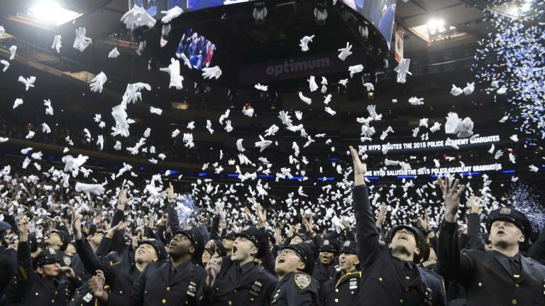 NYPD officer graduations, Dec. 29, 2015 15 Newly sworn police officers throw their gloves in the air at the conclusion of the New York City Police Academy graduation ceremony at Madison Square Garden in Manhattan on Tuesday, Dec. 29, 2015. More than 1,200 new police officers participated in the graduation ceremony.