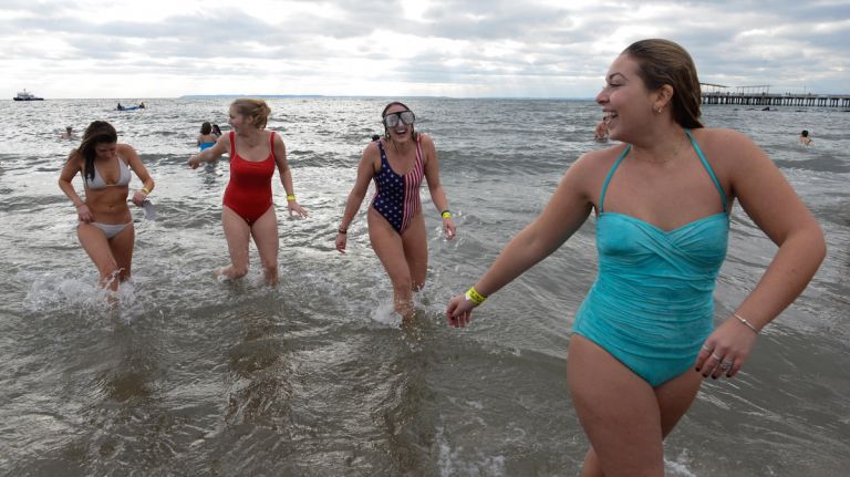 People in bathing suits run into the ocean during the annual Coney Island Polar Bear Club New Year's Day swim on Jan. 1, 2016.