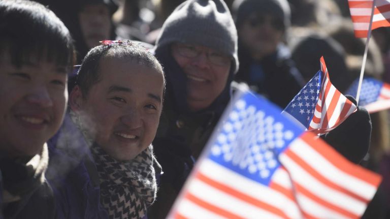 Spectators wave American flags at during the annual Lunar New Year Parade to welcome the Year of the Monkey in Manhattan's Chinatown on Sunday, Feb. 14, 2016. The monkey is the ninth of the 12-year cycle of animals that appear in the Chinese zodiac, related to the Chinese calendar.