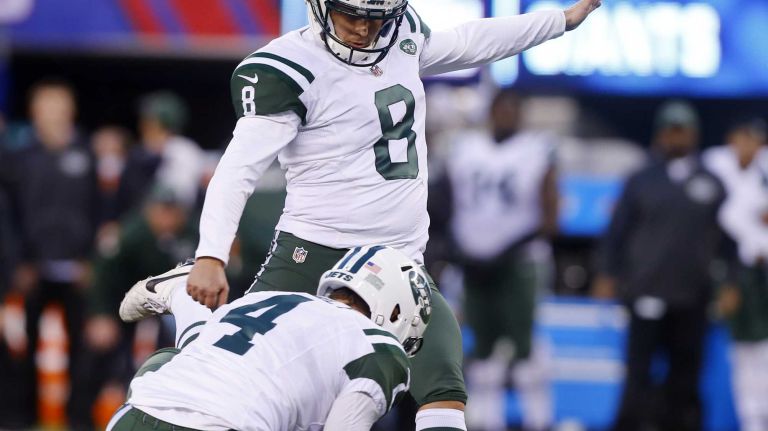 Randy Bullock #8 of the New York Jets kicks a field goal in overtime against the New York Giants as teammate Ryan Quigley #4 of the New York Jets holds at MetLife Stadium on Sunday, Dec. 6, 2015 in East Rutherford, New Jersey.