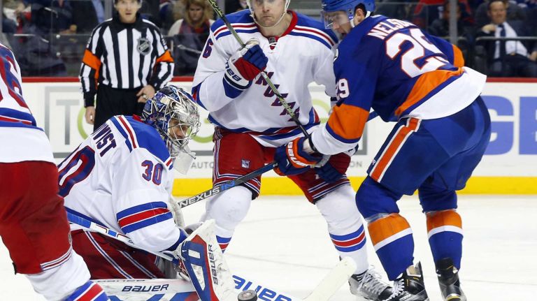 Henrik Lundqvist #30 of the New York Rangers makes a save as teammate Dylan McIlrath #6 defends against Brock Nelson #29 of the New York Islanders at Barclays Center on Wednesday, Dec. 30, 2015 in Brooklyn, New York.