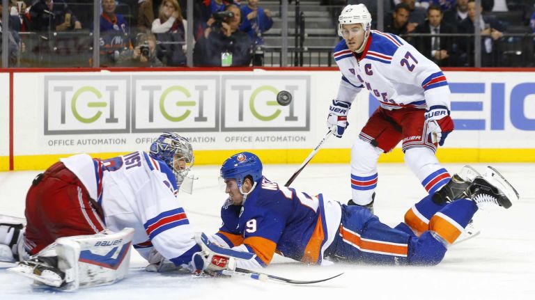 Brock Nelson #29 of the New York Islanders falls to the ice between Henrik Lundqvist #30 and Ryan McDonagh #27 of the New York Rangers at Barclays Center on Wednesday, Dec. 30, 2015 in Brooklyn, New York.