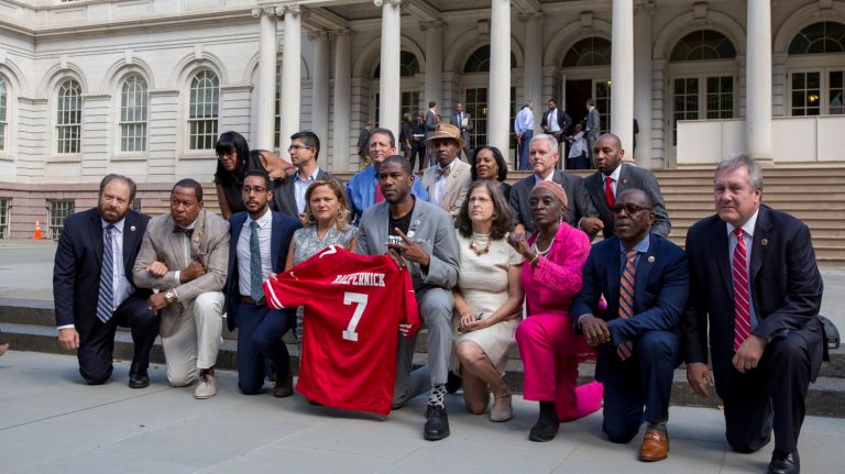 New York City Council members kneel  on the steps of City Hall in reaction to President's Donald Trump's profane condemnation of NFL players who do the same  during the national anthem. The council's action took place  on Sept. 27, 2017.