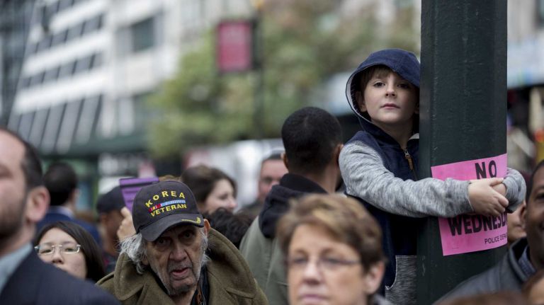 A young boy finds an elevated position to get a better view of the 96th annual New York City Veterans Day Parade in lower Manhattan on Wednesday, Nov. 11, 2015.
