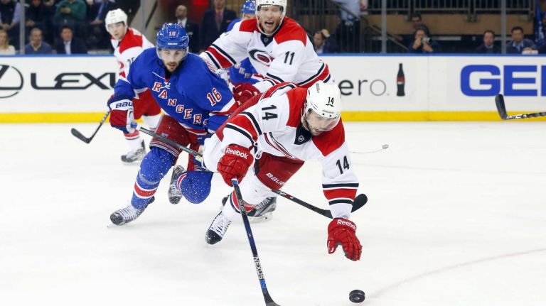 Nathan Gerbe of the Carolina Hurricanes tries to play the puck in the second period against Derick Brassard of the New York Rangers at Madison Square Garden on Tuesday, Nov. 10, 2015.