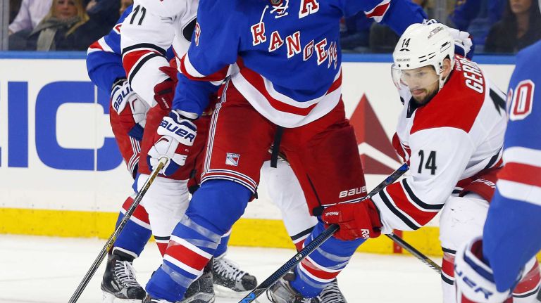 Marc Staal of the New York Rangers defends against Jordan Staal and Nathan Gerbe of the Carolina Hurricanes during the second period at Madison Square Garden on Tuesday, Nov. 10, 2015.