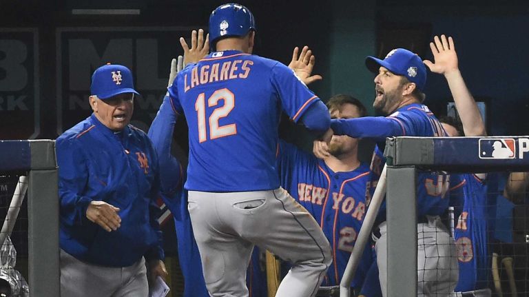 World Series Game 1: Mets vs. Royals 82 New York Mets manager Terry Collins (10) and teammates high five New York Mets center fielder Juan Lagares (12) after he scores go ahead run in eighth inning during Game 1 of the World Series against the Kansas City Royals at Kauffman Stadium on Tuesday, Oct. 27, 2015.