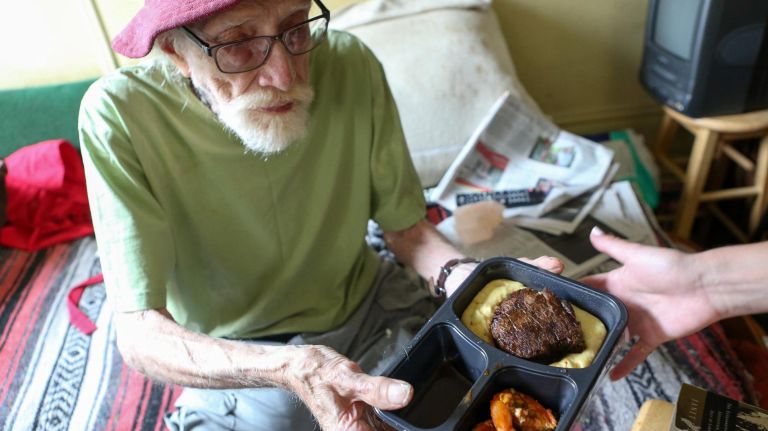 Upper East Side resident James Romeo receives a special gourmet meal prepared and delivered by chef David Burke through Citymeals on Wheel's Chefs Deliver program on Sept. 6, 2017. 