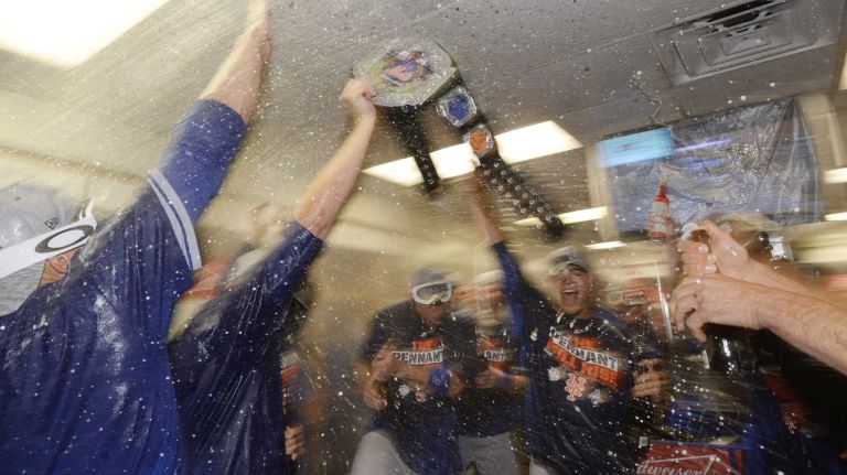 New York Mets left fielder Michael Cuddyer (23) lifts the New York Mets belt as they celebrate as the New York Mets celebrate in the locker room after winning the NLCS series against the Chicago Cubs at Wrigley Field on Wednesday, Oct. 21, 2015.
