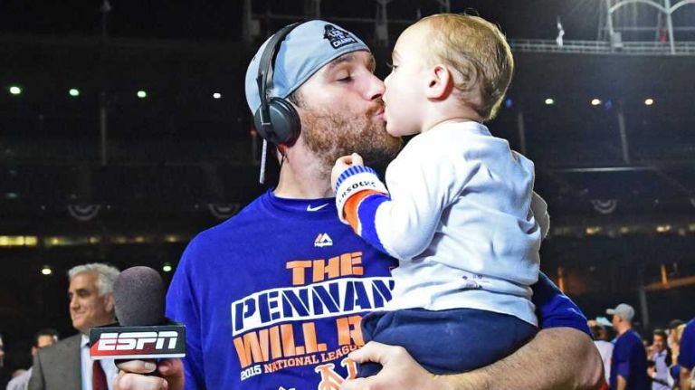 New York Mets second baseman Daniel Murphy kisses his son Noah as he celebrates his victory in Game 4 of the NLCS against the Chicago Cubs at Wrigley Field on Wednesday, Oct. 21, 2015.