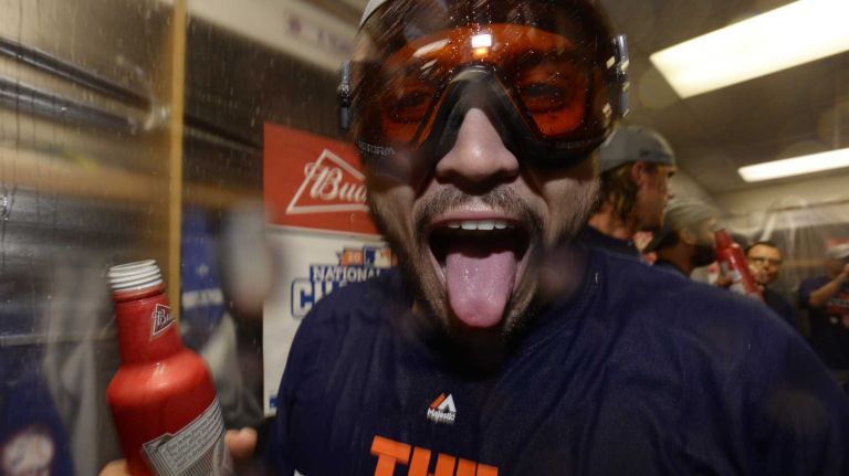 New York Mets catcher Travis d'Arnaud celebrates in the clubhouse after beating the Chicago Cubs in the NLCS at Wrigley Field on Wednesday, Oct. 21, 2015.