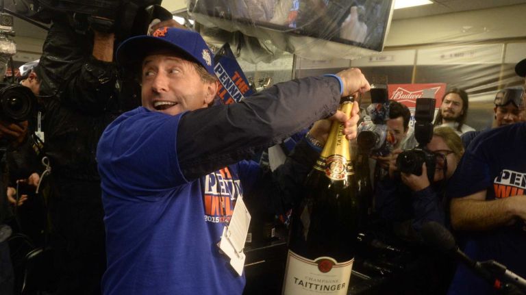 New York Mets owner Jeff Wilpon pops a huge bottle of champagne as the Mets celebrate in the clubhouse after beating the Chicago Cubs in the NLCS at Wrigley Field on Wednesday, Oct. 21, 2015.