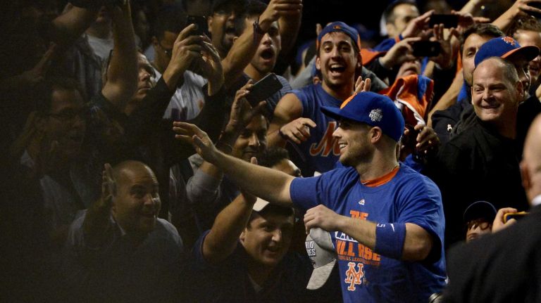 New York Mets third baseman David Wright celebrates his team's NLCS victory over the Chicago Cubs with fans at Wrigley Field on Wednesday, Oct. 21, 2015.