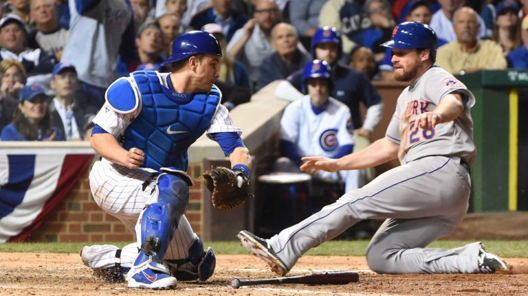 NLCS Game 3: Mets vs. Cubs 41 New York Mets second baseman Daniel Murphy scores on a ball hit by New York Mets first baseman Lucas Duda (21) as Chicago Cubs catcher Miguel Montero (47) is late with tag in the seventh inning during Game 3 of the NLCS at Wrigley Field on Tuesday, Oct. 20, 2015.