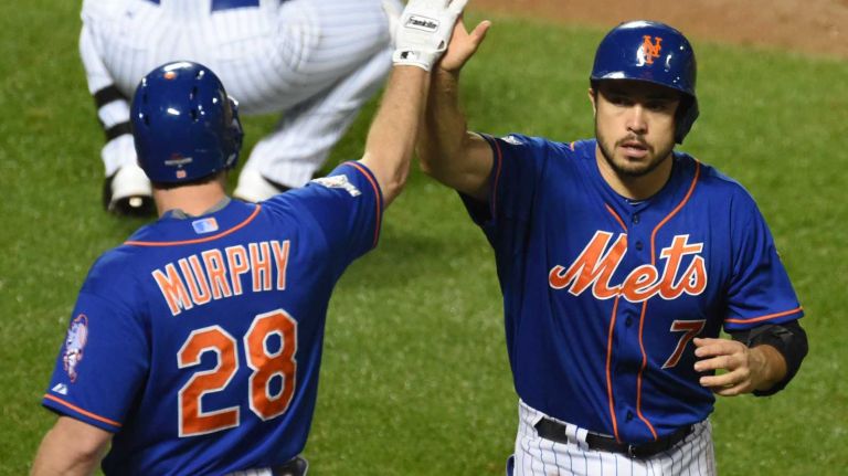 New York Mets second baseman Daniel Murphy (28) high-fives teammate catcher Travis d'Arnaud (7) after scoring in the second inning during Game 3 of the NLDS against the Los Angeles Dodgers on Monday, Oct. 12, 2015.