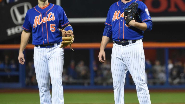 New York Mets third baseman David Wright (5) and starting pitcher Matt Harvey (33) react as the start of Game 3 of the NLDS against the Los Angeles Dodgers was delayed on Monday, Oct. 12, 2015.