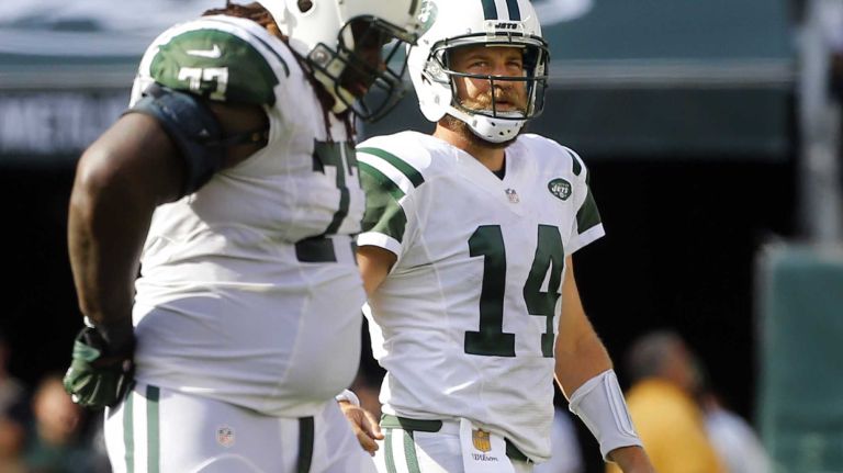 Ryan Fitzpatrick #14 and James Carpenter #77 of the New York Jets walk to the sidelines after an interception in the fourth quarter against the Philadelphia Eagles during an NFL game at MetLife Stadium on Sept. 27, 2015.