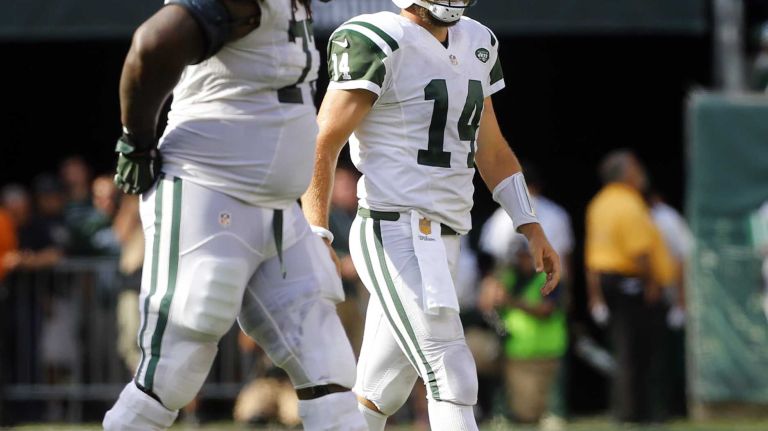 Ryan Fitzpatrick #14 and James Carpenter #77 of the New York Jets walk to the sidelines after an interception in the fourth quarter against the Philadelphia Eagles during an NFL game at MetLife Stadium on Sept. 27, 2015.